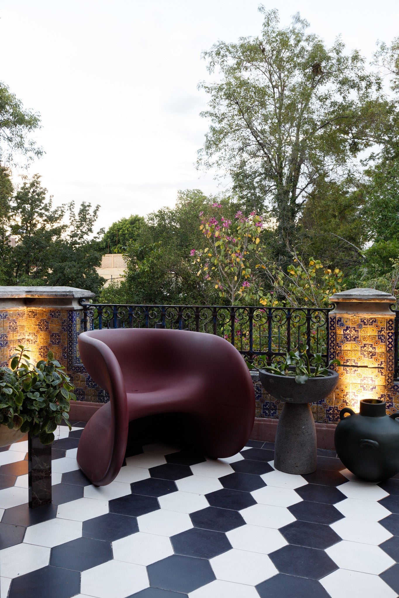 Fortune Chair by Heller in Dark Cherry on a modern patio in mexico with decorative tiles and plants.